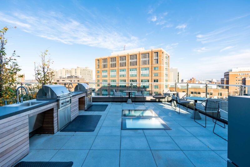 rooftop terrace with BBQ grills, seating areas and fire pit